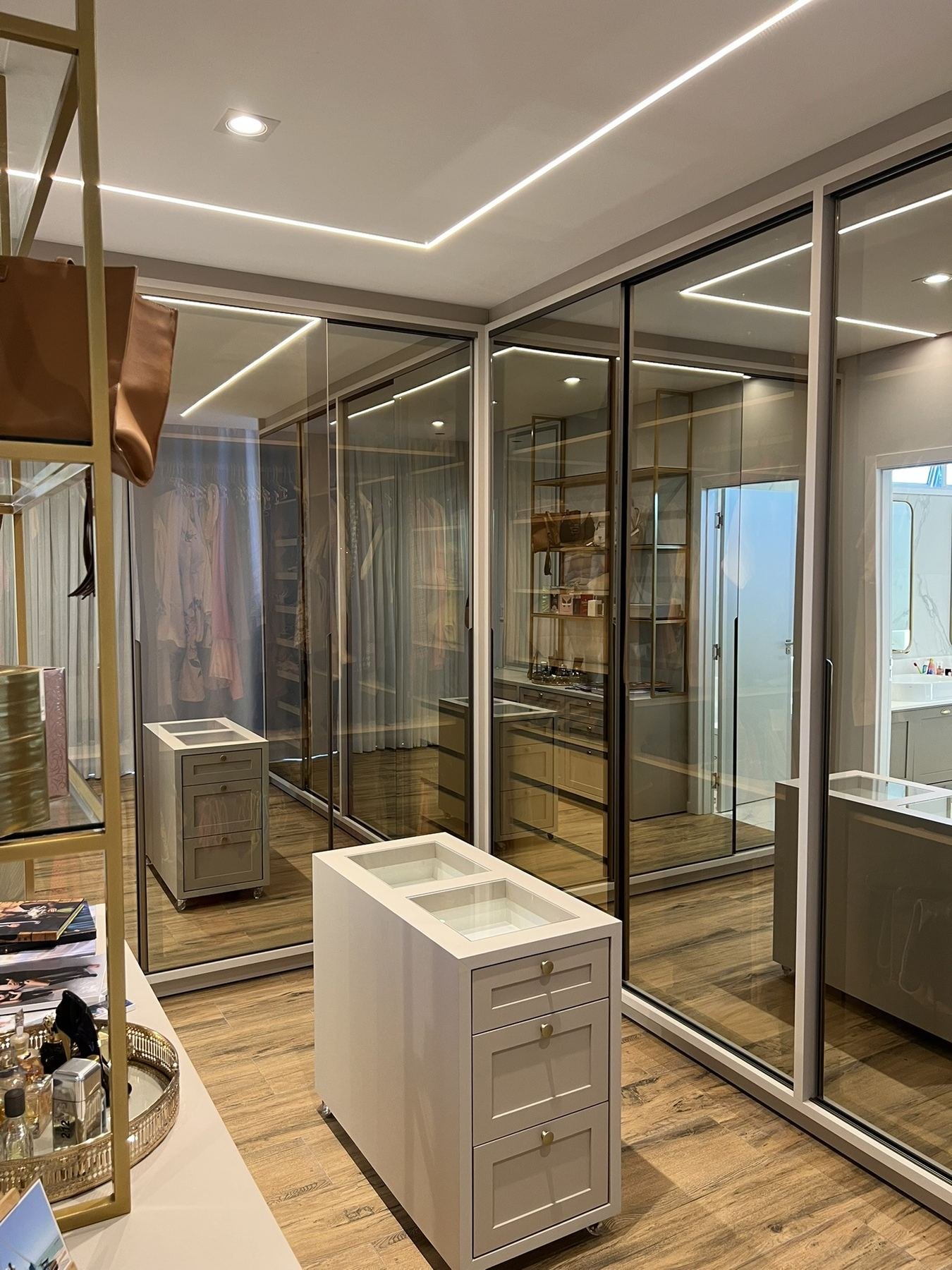 Closet planejado com portas espelhadas e ilha central