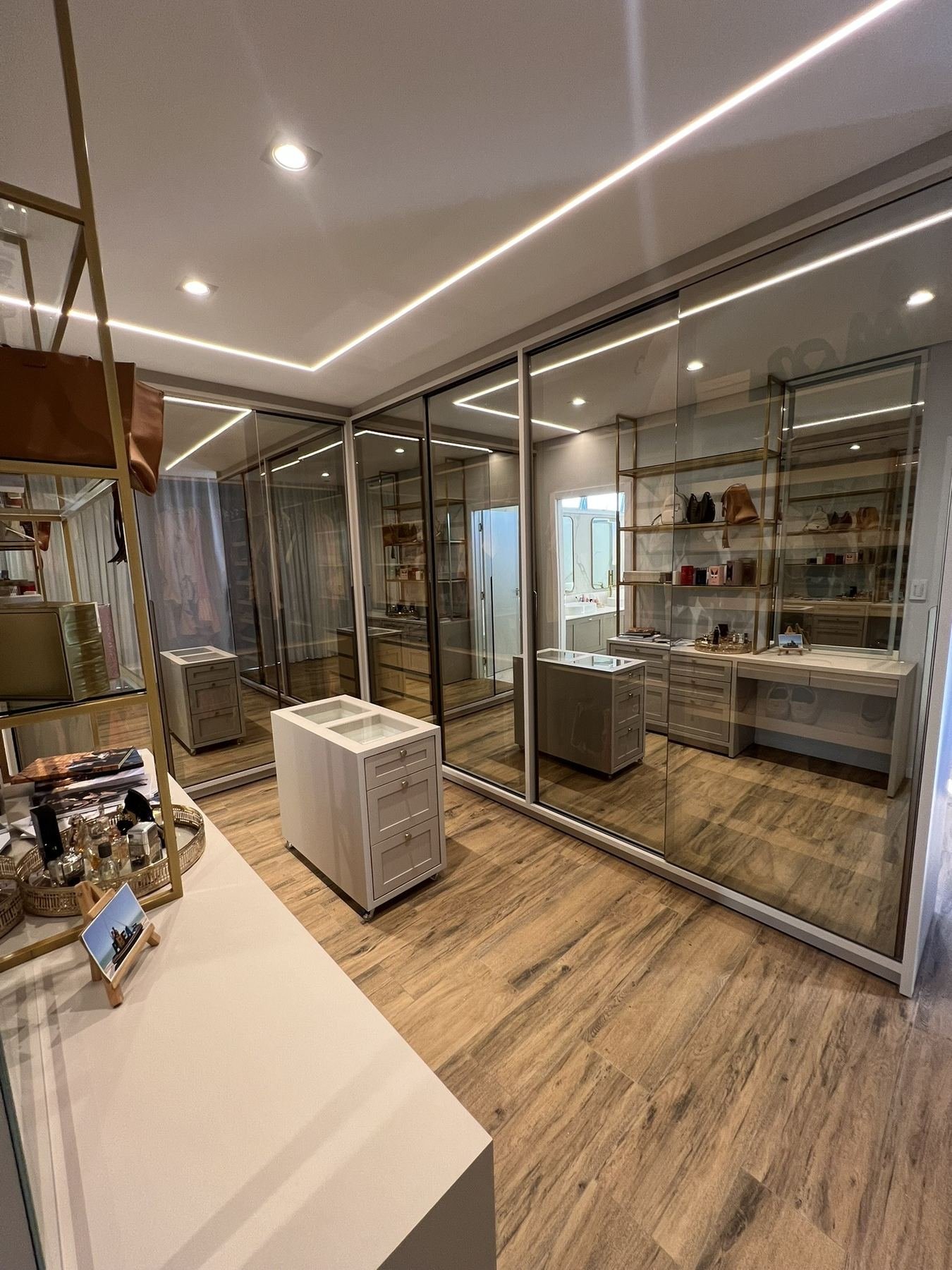 Closet planejado com espelho, bancada e iluminação embutida