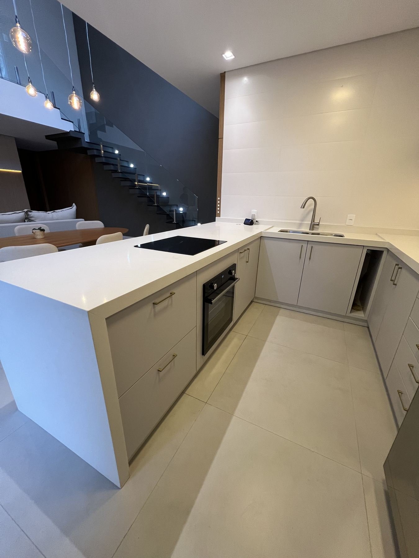 Cozinha planejada em U com ilha central e vista para o mar
