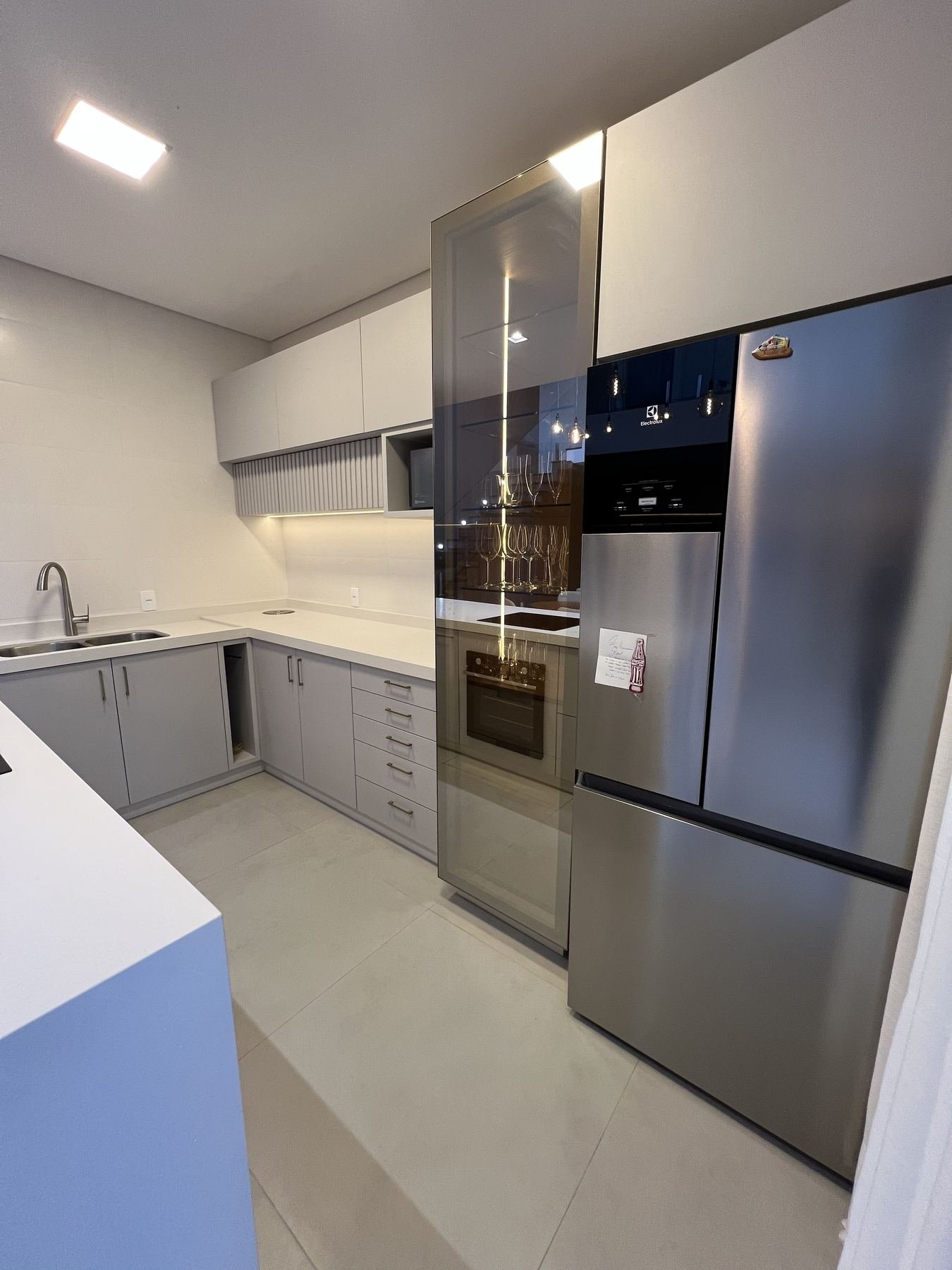 Cozinha planejada com adega de vidro e eletrodomésticos embutidos