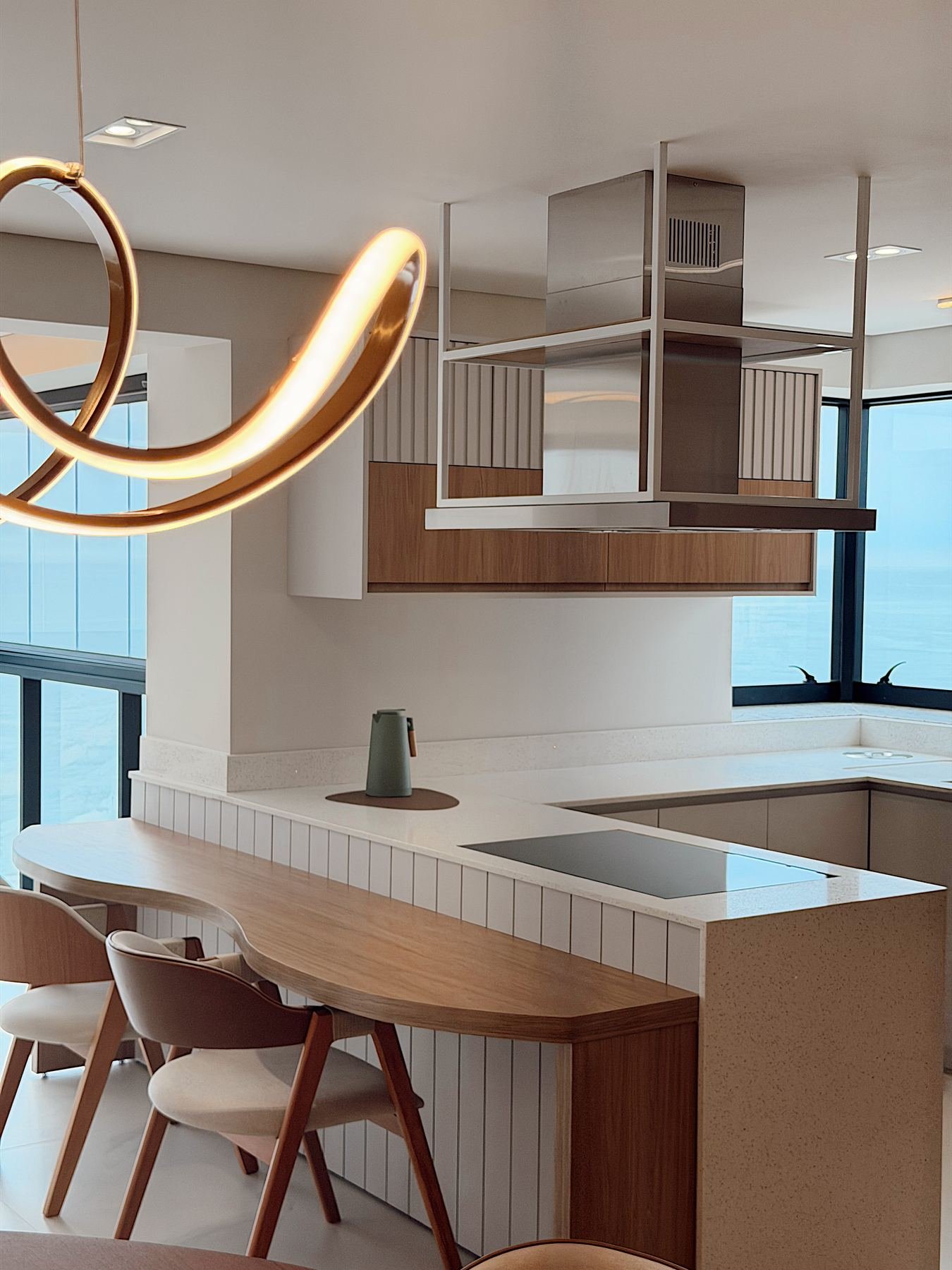 Cozinha planejada com armário suspenso, pendente decorativo e forro em madeira