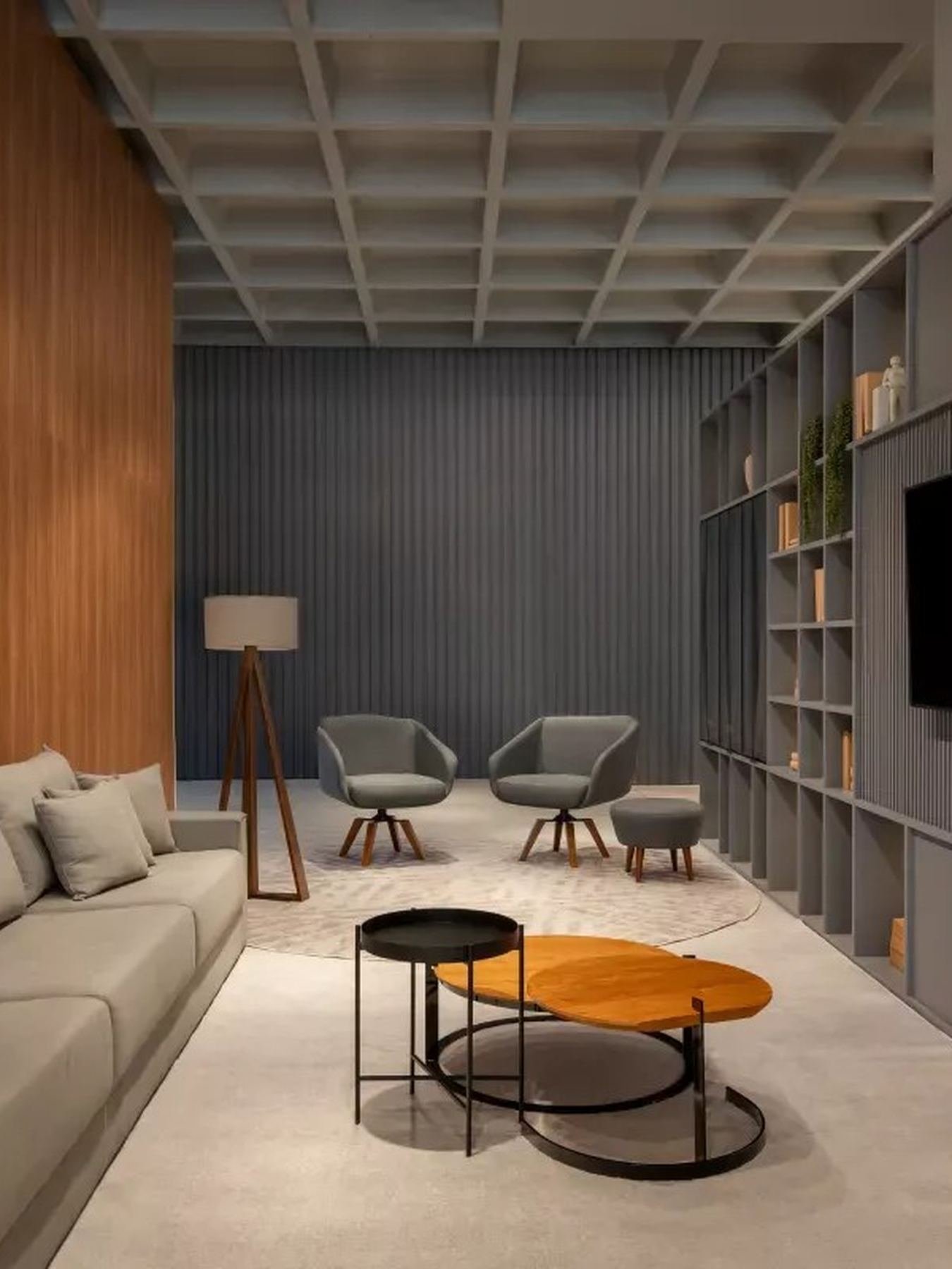 Sala de estar planejada com estante, poltrona e mesas de centro