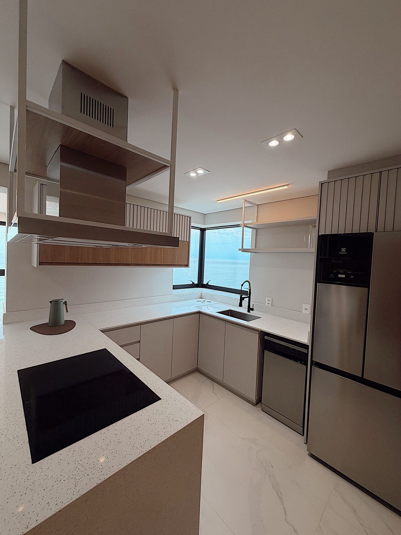Sala de estar integrada à cozinha, com pé-direito duplo
