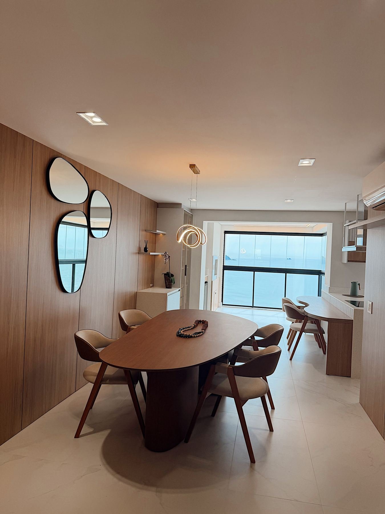 Sala de jantar planejada com mesa redonda e espelhos decorativos